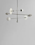 Modern chandelier with white glass shades on a gray background