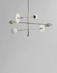 Modern chandelier with white glass shades on a gray background