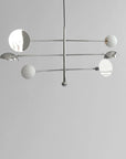 Modern chandelier with white spherical lights on a gray background