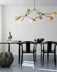 Modern dining room with black table and chairs, decorative vases, and a chandelier.
