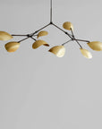 Modern chandelier in brass finish on a gray background from 101 Copenhagen available at Spacio retail stores in Mumbai & Kolkata.
