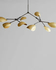 Modern chandelier in brass finish on a gray background from 101 Copenhagen available at Spacio retail stores in Mumbai & Kolkata.