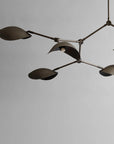 Modern chandelier with multiple lampshades on a plain background