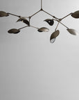Modern chandelier with leaf-like design on a plain background in bronze finish from 101 Copenhagen available at Spacio retail stores in Mumbai & Kolkata.