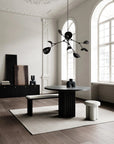 Modern dining room with a black round table and stylish chandelier.