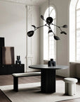 Modern dining room with a black round table and stylish chandelier.