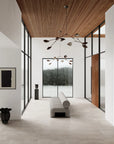 Modern interior with large windows, wooden ceiling, and minimal decor.