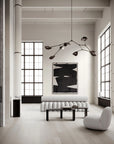 Modern living room with white walls, large windows, and minimal furniture.