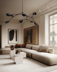 Modern living room with a sectional sofa, abstract art, and large windows.