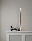 Modern floor lamp on a white cabinet against a gray wall