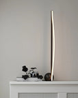 Modern floor lamp on a white cabinet against a gray wall