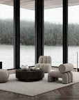 Modern living room with gray furniture and large windows overlooking a lake.
