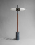 Modern floor lamp with a cylindrical base on a gray background