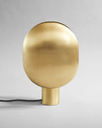 Brass table lamp on a gray background from 101 Copenhagen available at Spacio retail stores in Mumbai & Kolkata.