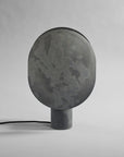 Dark gray concrete lamp on a light gray background from 101 Copenhagen available at Spacio retail stores in Mumbai & Kolkata.