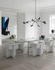 Modern dining room with a glass table and white chairs in a minimalistic setting.