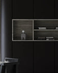 Modern interior with black cabinets and wooden shelves with a sculptural table lamp.