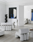 Modern living room with white furniture, abstract art, and a neutral color palette.