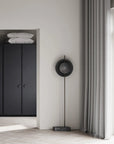 Modern interior with a black wardrobe, mirror, and floor lamp.