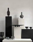 Collection of black ceramic vases and bowls on a neutral background from 101 Copenhagen at Spacio retail stores in Mumbai & Kolkata.