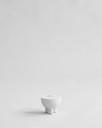 White ceramic bowl with lid on a light gray background from 101 Copenhagen at Spacio retail stores in Mumbai & Kolkata.