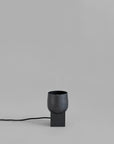 Black lamp with a cylindrical shade on a gray background