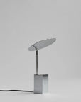 Modern table lamp with a reflective shade on a gray background