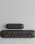 Two coffee colour Shinju platters with textured ends on a light gray background from 101 Copenhagen at Spacio retail stores in Mumbai & Kolkata.