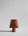 Terracotta colour ceramic vase on a light gray background from 101 Copenhagen available at Spacio retail and online stores in India.