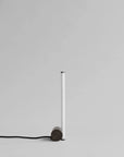 Modern pendant light with cylindrical shade and black cord on a gray background