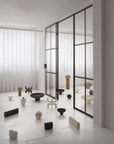 Modern interior with glass walls and various ceramic sculptures on a light floor.