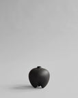 Black ceramic vase on a light gray background from 101 Copenhagen at Spacio retail stores in Mumbai & Kolkata.