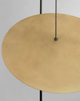 Gold circular object with black hanging cables on a gray background