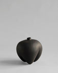 Black ceramic vase on a light gray background from 101 Copenhagen at Spacio retail stores in Mumbai & Kolkata.