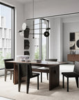 A modern dining table and chairs in a room with large windows. The dining set features the 101Cph Empire Mini Dark Grey 223036 table, which is made of ceramic and comes in a stylish dark grey color.
