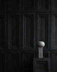 An empty room with 101Cph Empire Mini Dark Grey 223036 walls and a ceramic pedestal. (Brand Name: 101 Copenhagen)