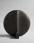 A black vase on a grey background, inspired by the 101 Copenhagen Arts Movement.