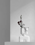 The Double Mini Bubble White Vase from 101cph with decorative flowers and foliage