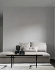 A living room with a 101Cph Cobra Uno Mini Black 203024 couch and a white rug decorated with quirky vases by 101 Copenhagen.