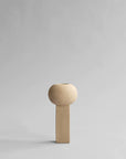A small wooden 101Cph Empire Mini Sand 223037 on a grey background, quirky and unique in its design, reminiscent of the 101 Copenhagen Arts Movement.