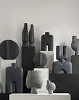 A group of 101Cph Guggenheim Mini Coffee 111220 vases by 101 Copenhagen on a table.