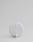 A quirky 101Cph Guggenheim Petit Bone White 213043 vase from the Cobra Arts Movement sitting on a grey surface. (Brand Name: 101 Copenhagen)