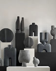 Collection of black and gray ceramic sculptures on a neutral background
