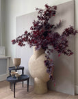 Decorative vase with purple leaves against a neutral wall along with bowls from 101 Copenhagen