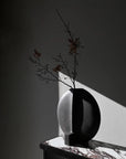 Black and white vase with branches styled on a Fibre concrete and calacatta marble top console from 101 Copenhagen at Spacio retail stores in Mumbai & Kolkata.