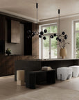 Modern living room with dark wood furniture, white stools, and decorative lighting.
