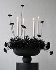 Candle holder with black flowers on a gray background in a ceramic bowl from 101 Copenhagen at Spacio retail stores in Mumbai & Kolkata.