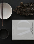 Book titled 'A Century of Style' by Architectural Digest on a dark surface with decorative items from 101 Copenhagen at Spacio retail stores in Mumbai & Kolkata.