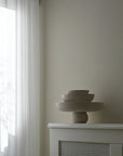Three ceramic bowls on a white surface with a neutral wall and window in the background from 101 Copenhagen at Spacio retail stores in Mumbai & Kolkata.
