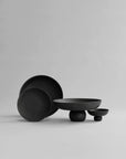 Set of black ceramic bowls on a light gray background from 101 Copenhagen at Spacio retail stores in Mumbai & Kolkata.